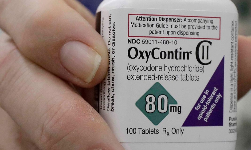 En esta imagen de archivo del 2 de abril de 2018, una farmacéutica en San Francisco posa sosteniendo un frasco de OxyContin. (AP / Jeff Chiu)
